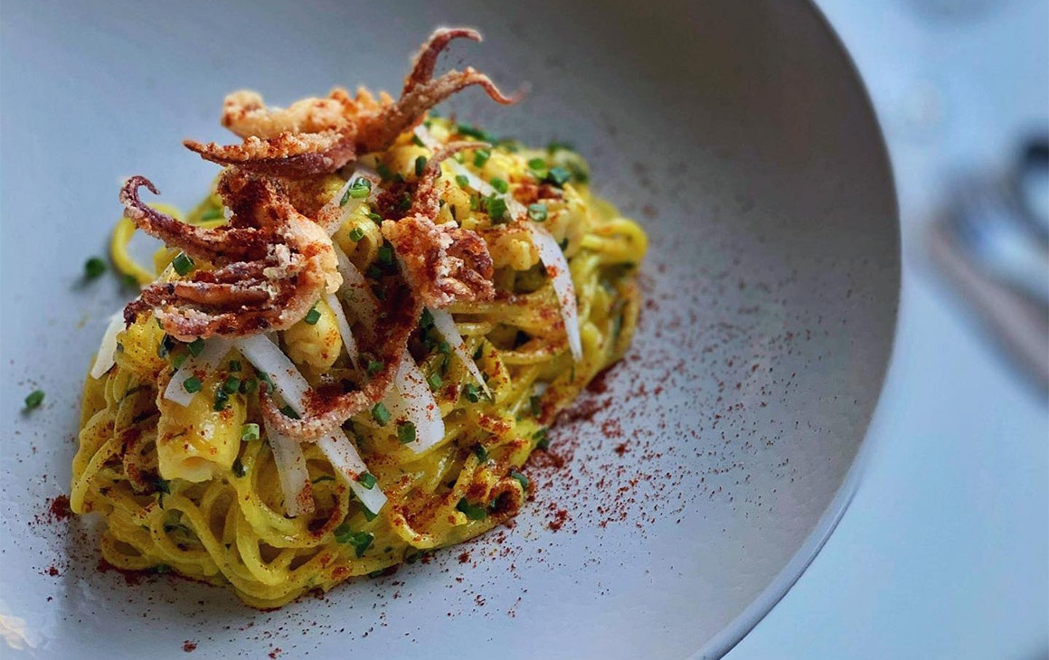 a plate of spaghetti topped with crispy octopus